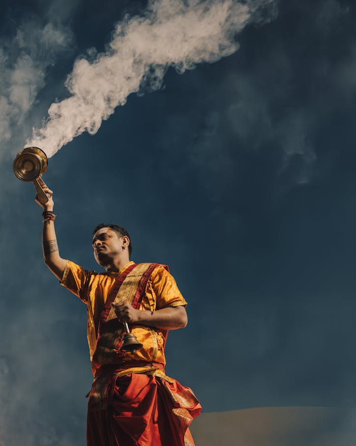 Man performing a cultural ritual with incense smoke, emphasizing spirituality and tradition.