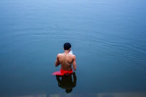 A man performs a traditional prayer ritual in the Ganges River at Varanasi, India.