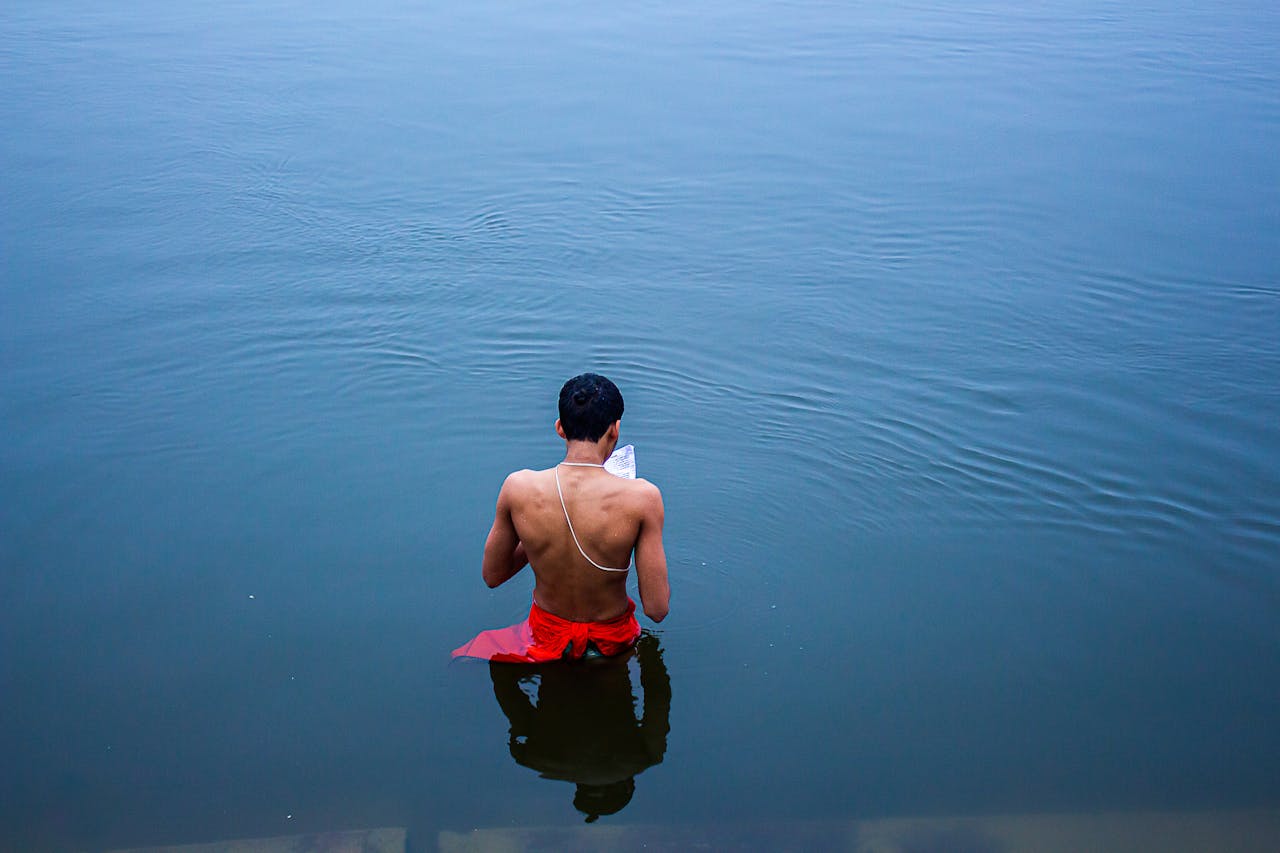 A man performs a traditional prayer ritual in the Ganges River at Varanasi, India.